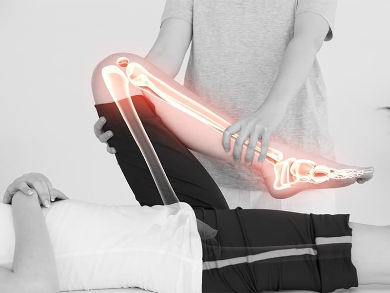 physiotherpist working on patients kneee shows internal bone workings