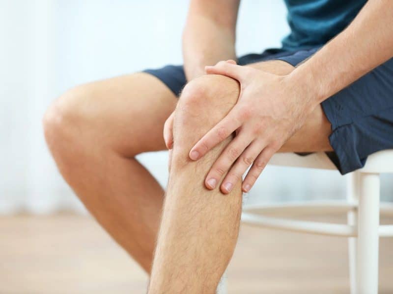 Clos image of man holding his sore knee