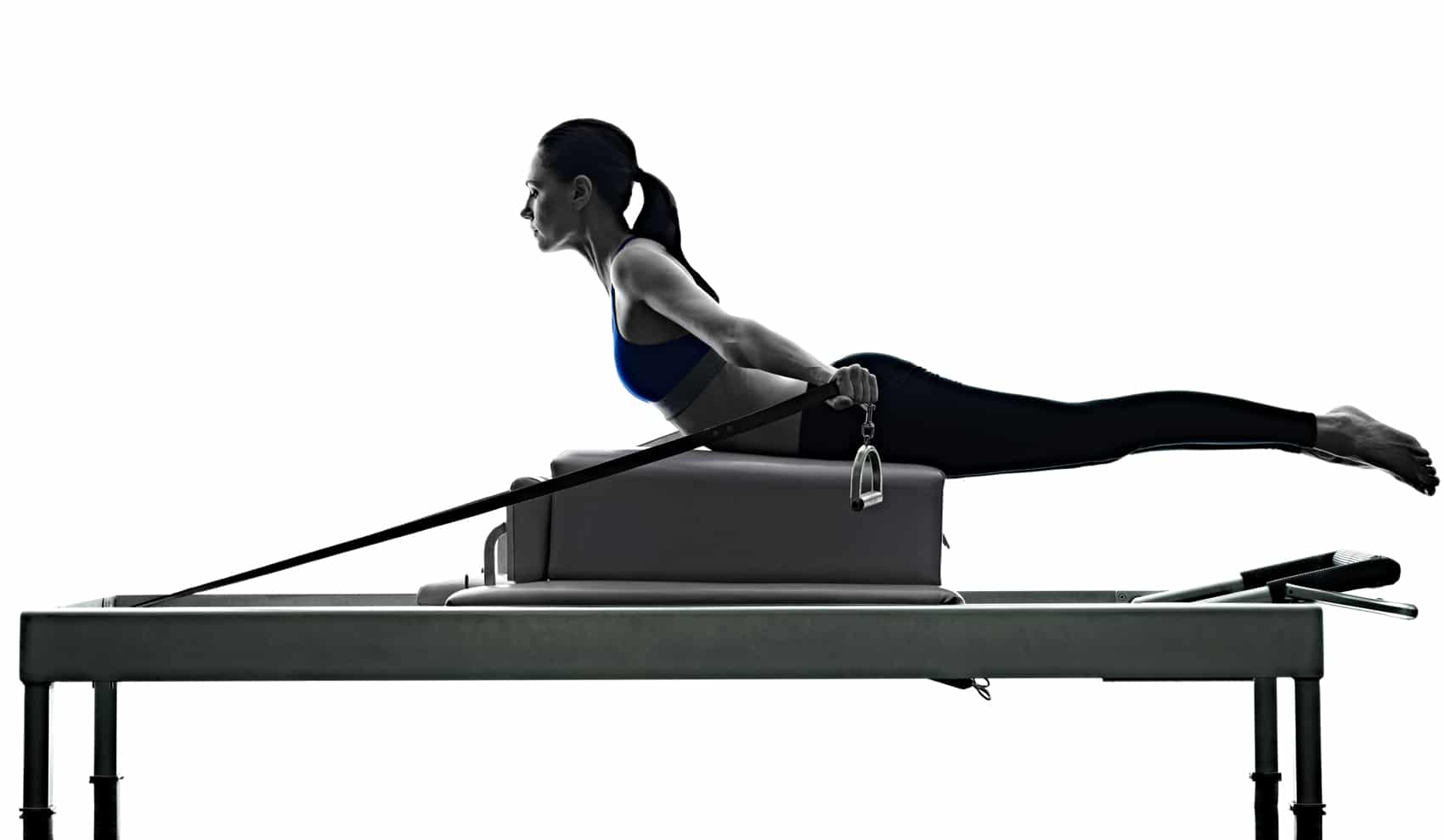 Silhouette image of lady using pilates bed