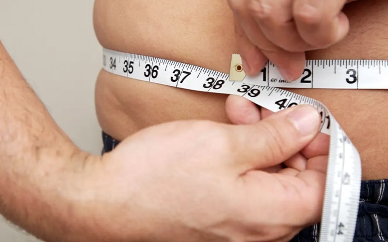 person with tape measure around waist