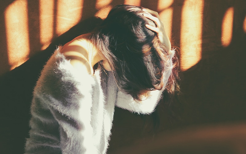 women holding head in stress